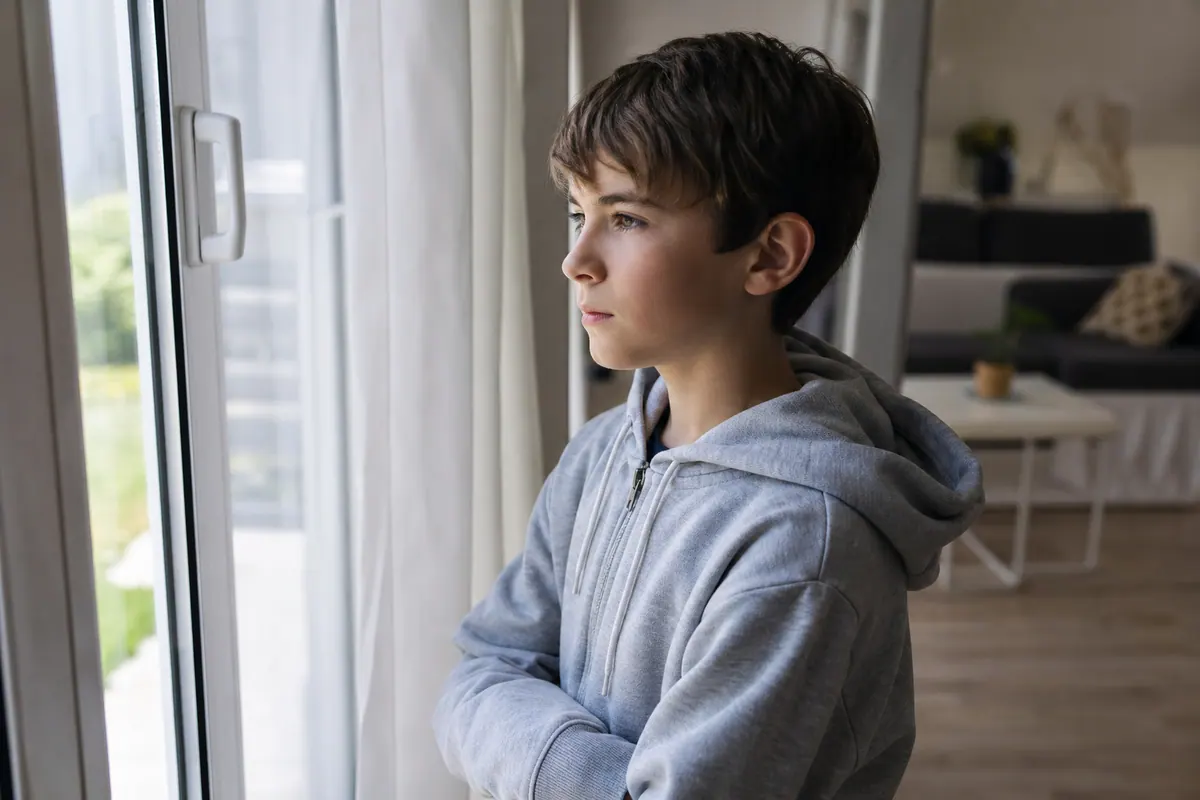 Enfant lisant seul et paisiblement dans un salon lumineux