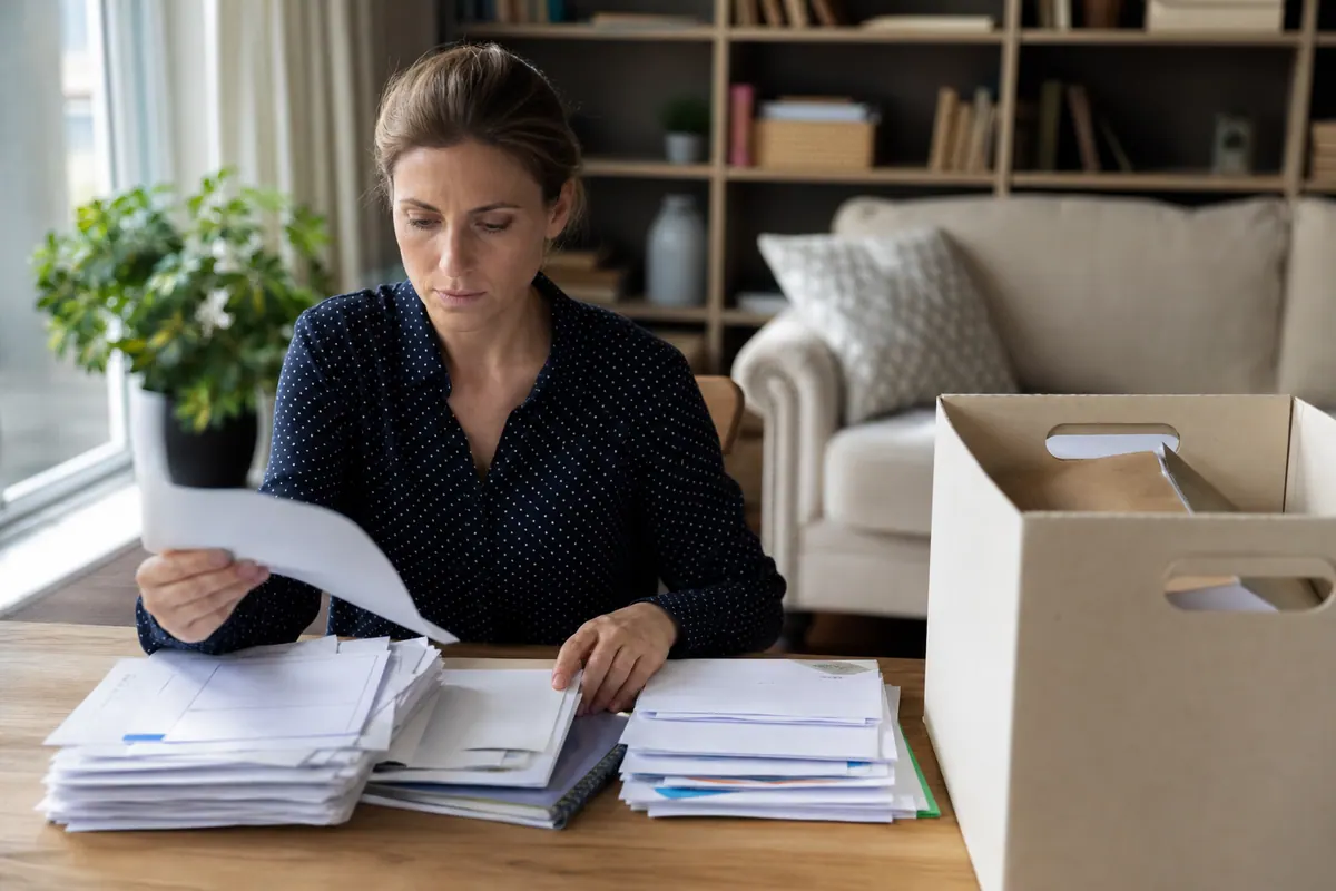 Classeur de documents administratifs et factures rangés sur une table en bois
