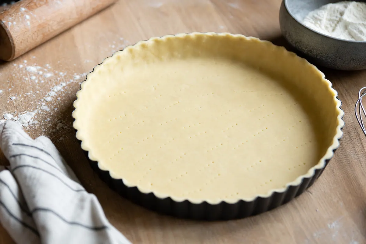 Fond de tarte en pâte brisée disposé dans un moule, prêt à être enfourné, cuisine lumineuse