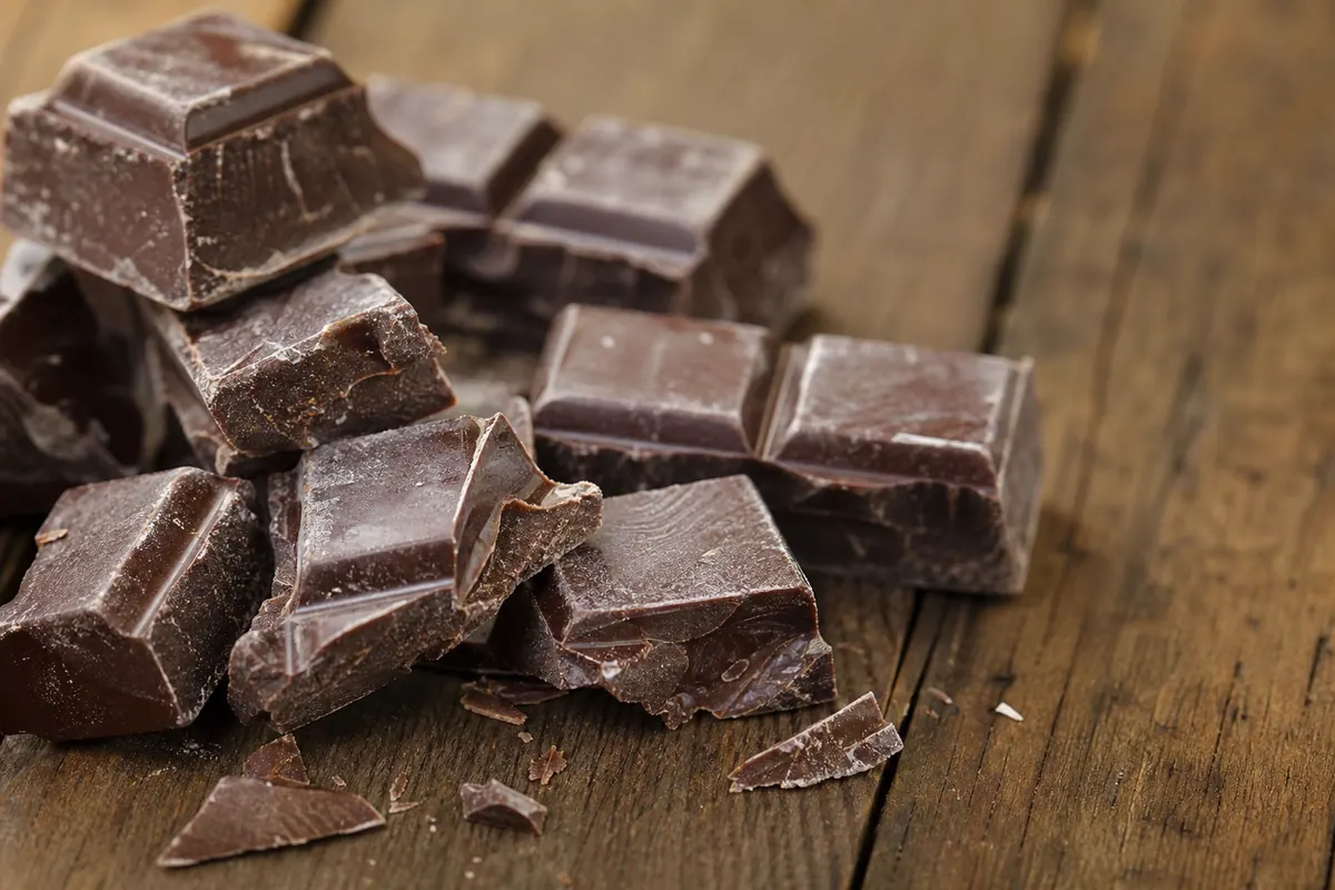 Tablette de chocolat brisée en morceaux, avec une légère patine blanchâtre visible en surface